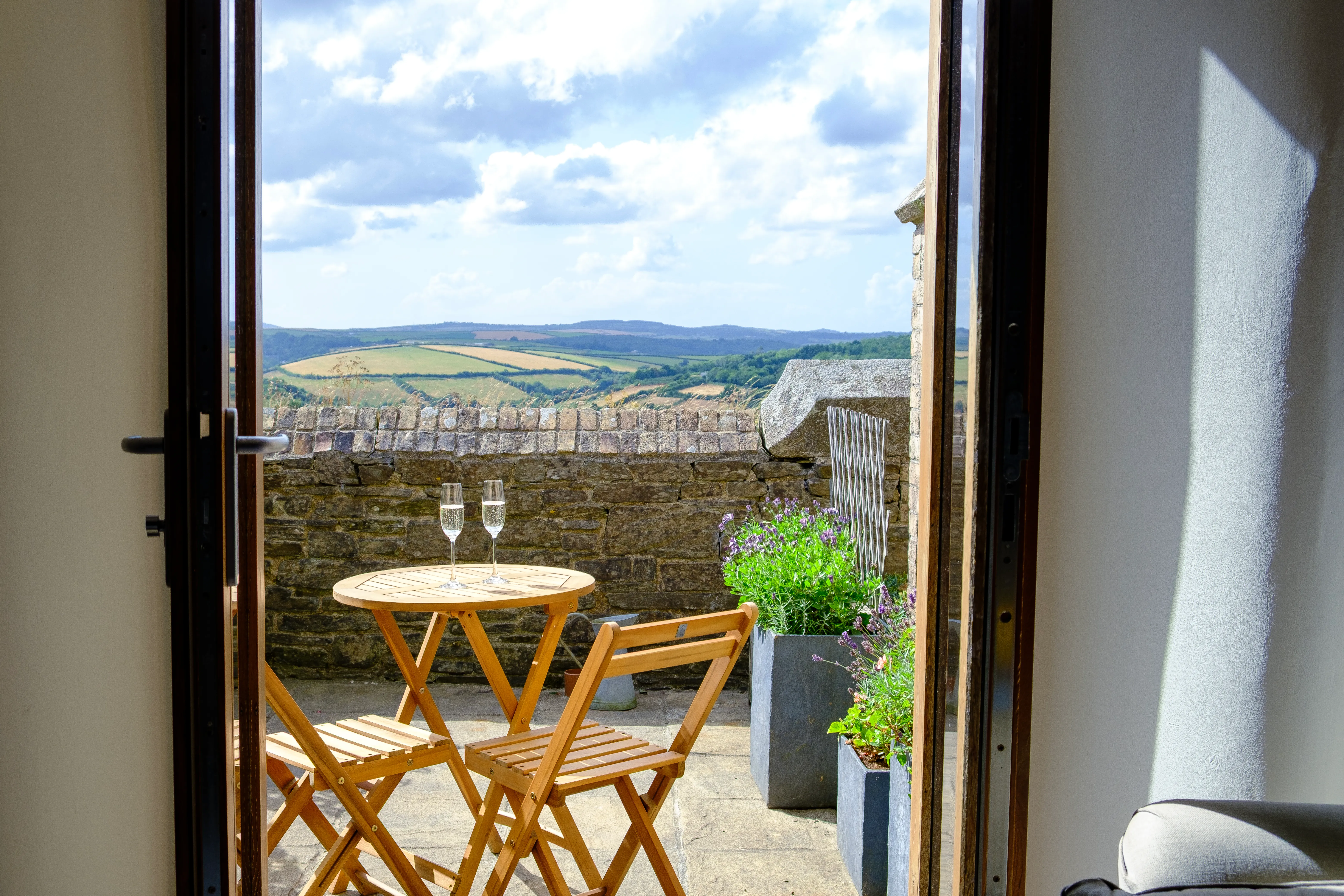 Two glasses of champagne on a bistro table in the courtyard