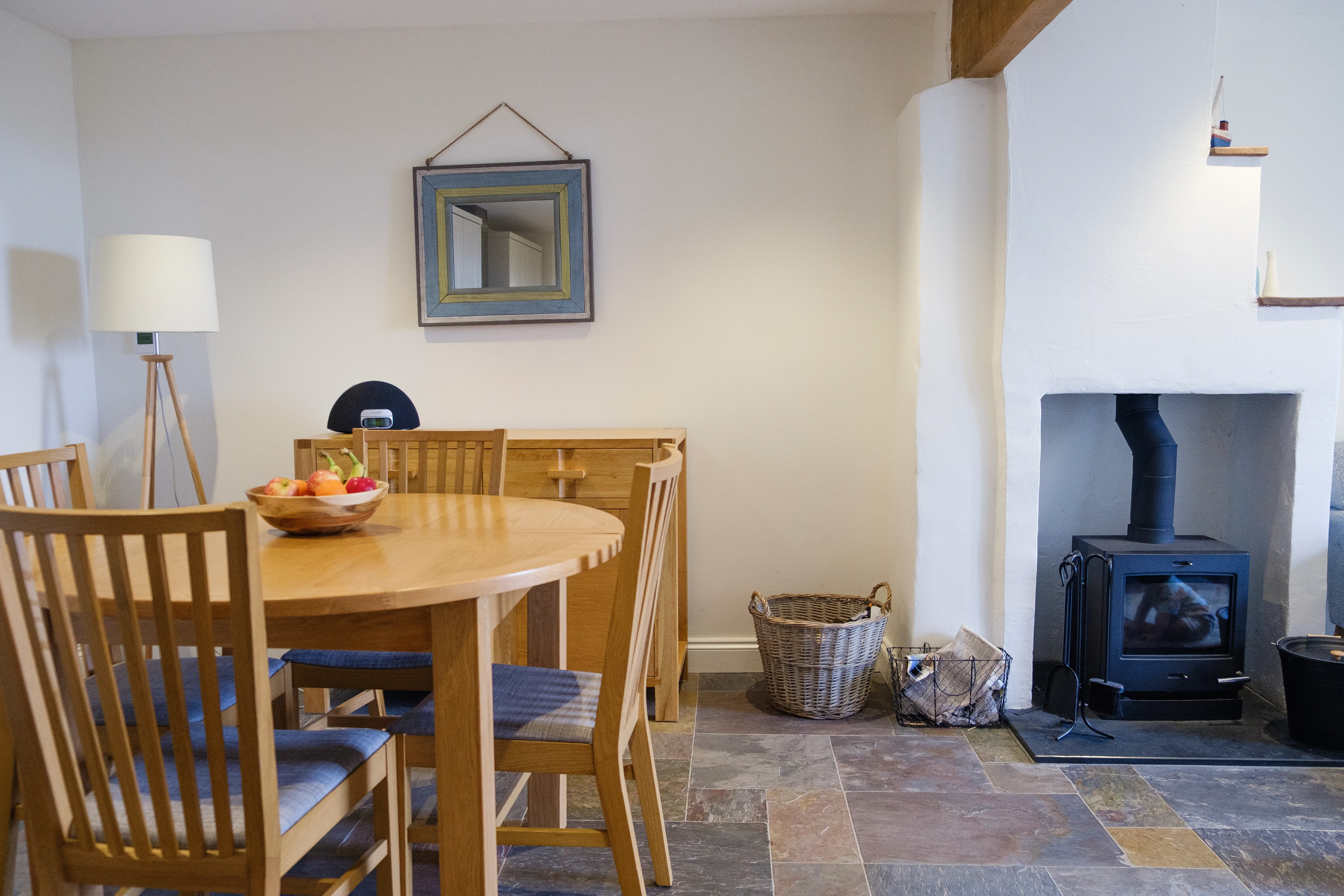 A round dining table set for four people, with a fruit bowl.